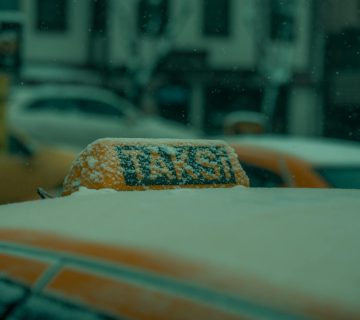 Close-up of a snow-covered taxi roof in winter, capturing a chilly street scene in Bursa, Turkey.
