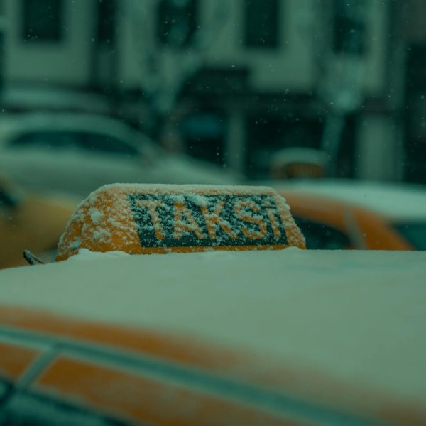 Close-up of a snow-covered taxi roof in winter, capturing a chilly street scene in Bursa, Turkey.